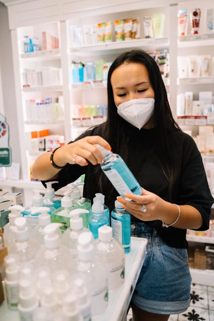 woman in black shirt holding a bottle of hand sanitizer