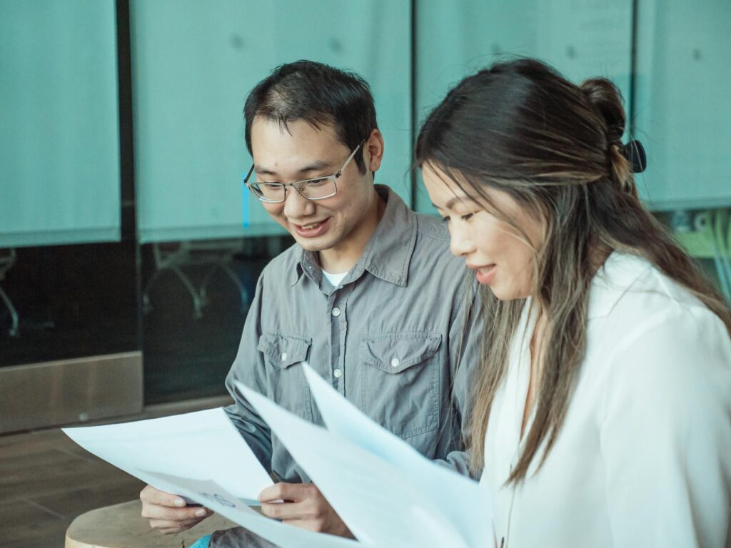 man and woman holding papers